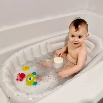 dans une salle bain bébé prend son bain dans sa baignoire bebe gonflable