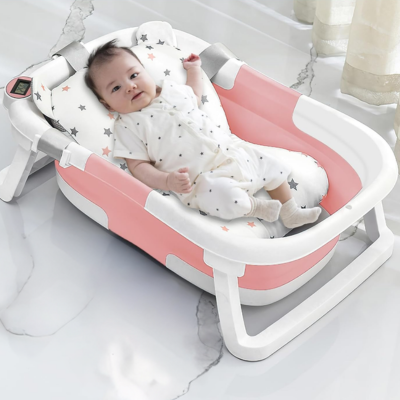 bébé souriant dans baignoire bébé pliable avec coussin moelleux