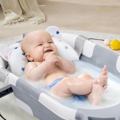 bébé souriant confortablement allongé sur coussin moelleux prend son bain dans baignoire bébé pliable