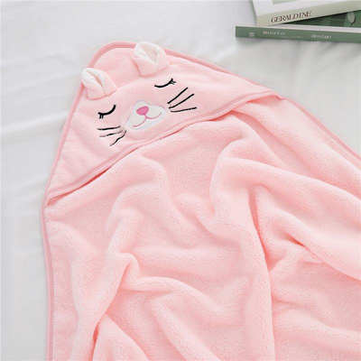 cape de bain bébé capuche design chat rose étendue sur lit