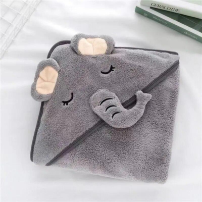 Une cape de bain bébé pliée, avec un design d'éléphant gris avec des grandes oreilles très douces et une trompe brodée. L'expression de l'éléphant est mignonne, paisible et charmante.