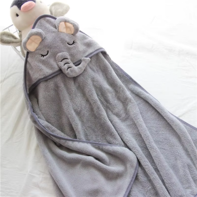 Une cape de bain bébé déployée, mettant en valeur son design élégant en forme d'éléphant gris. La capuche est décorée d'adorables oreilles rembourrées et d'une trompe en relief, parfaite pour garder les bébés au chaud après le bain.