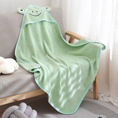 cape bain bebe verte-capuche-grenouille posée sur canapé