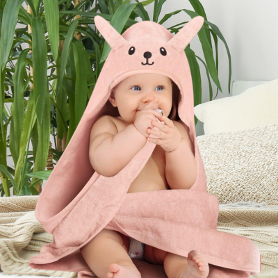 bébé assis sur lit porte cape de bain bebe avec capuche design lapin