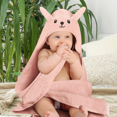 bébé-assis-sur-lit-porte-cape-de-bain-bébé-avec-capuche-design-lapin