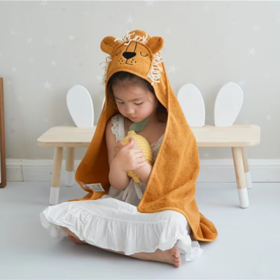 petite fille assise porte cape bain bebe lion capuche crinière