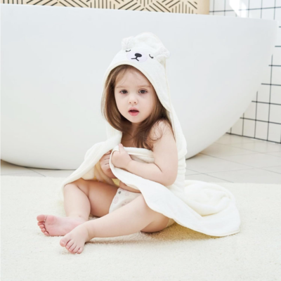 enfant assis dans salle bain porte cape-de bain bébé ours