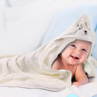 enfant emmailloté dans cape de bain bébé avec capuche ours sur tête