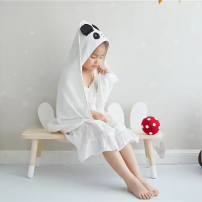 fillette assise sur banc porte cape bain bebe capuche design panda