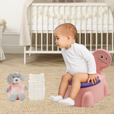 bébé assis sur pot bebe dinosaure rose rigolo regarde couches au sol