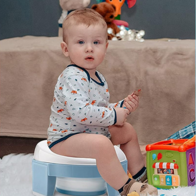 petit-garçon-assis-sur-pot-bebe-toilette-bleu-avec-jouets