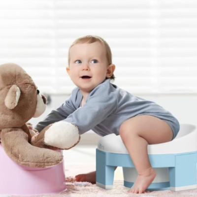 bébé-assis-sur-pot-bebe-toilette-bleu-joue-avec-doudou