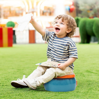 jeune enfant souriant assis sur pot toilette bebe forme citrouille dans un parc
